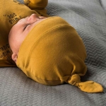 Een set van 2 okergele knoopmutjes. Het ene mutsje is effen van kleur en het andere mutsje heeft een print met de tekst 'I have a Wild Side'.