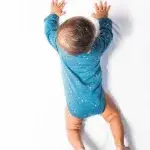 Een leuke romper met lange mouwen in een blauwe kleur. Het rompertje heeft printjes van een leeuwengezichtje in de kleur wit.