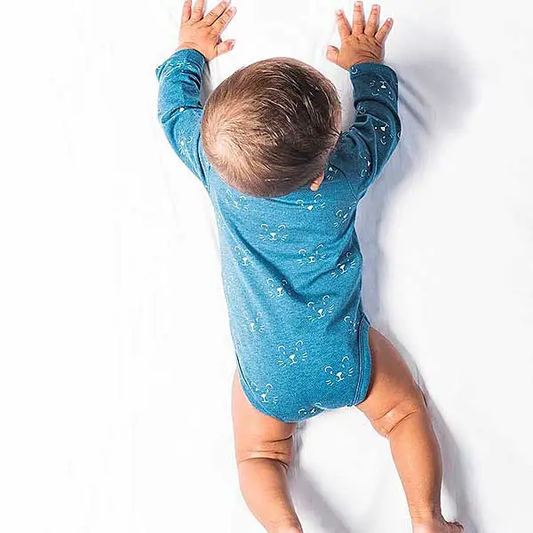 Een leuke romper met lange mouwen in een blauwe kleur. Het rompertje heeft printjes van een leeuwengezichtje in de kleur wit.