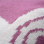 Een heerlijke deken voor in het wiegje. Dit dekentje is roze van kleur met de afbeelding van een luiaard. De luiaard is er in geweven in de kleur wit.