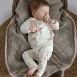 Een heerlijk zacht boxpakje Flamingo in de kleur gebroken wit, zonder voetjes, van soepele tricot met een leuke flamingo print uit de collectie van Hot Pink.