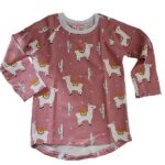 Een hip shirtje met lange mouwen in de kleur roze. Het shirtje heeft een bedrukking van lama's & cactussen. De hals is afgezet met een witte bies. Gemaakt van biologisch katoen.