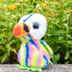 Knuffel Puffin Lenni van Lumo Stars in regenboogkleuren met grote glanzende ogen en zachte pluche vacht