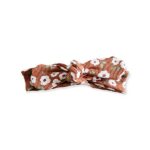 De knoophaarbandje Rib Flowers Brique is gemaakt van zacht rib katoen in de kleur oranjebruin met witte bloemen. Geschikt voor de leeftijd 0-6 maanden en komt uit de collectie van Little Adventure.