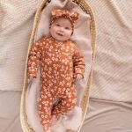 De knoophaarbandje Rib Flowers Brique is gemaakt van zacht rib katoen in de kleur oranjebruin met witte bloemen. Geschikt voor de leeftijd 0-6 maanden en komt uit de collectie van Little Adventure.