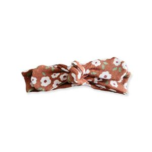 De knoophaarbandje Rib Flowers Brique is gemaakt van zacht rib katoen in de kleur oranjebruin met witte bloemen. Geschikt voor de leeftijd 0-6 maanden en komt uit de collectie van Little Adventure.