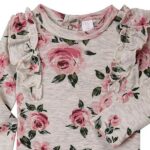 Een schattig grijs rompertje met lange mouwen. Het rompertje heeft ruches op de schouders. Het rompertje is voorzien van een bedrukking van roze rozen. Gemaakt van 100% katoen. 