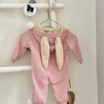 Leuke onesies in de kleur roze. De onesie is voor zien van een rits en een capuchon met daarop 2 konijnenoren. De oortjes hebben een witte binnenkant. Het pakje heeft geen voetjes.