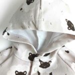 Een heerlijk zachte ecru kleurige onesie met capuchon. Gemaakt van soepele tricot met een leuke print van schapen hoofdjes uit de collectie van Hot Pink. De onesie heeft geen voetjes. 