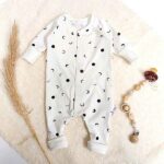 Een heerlijk zacht gebroken wit boxpakje, zonder voetjes, van soepele tricot met bedrukkingen van de maan uit de collectie van Hot Pink.