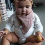Deze bandana slab Misty Rose beschermt de kleertjes van je kindje tegen kwijlen gedurende de dag maar kan ook als accessoire worden gebruikt.
