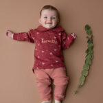 Dit leuke broekje is effen roze met 2 steekzakjes. De steekzakjes zijn afgezet met een lichtroze bies. Onder op het pijpje zit het logo van Little Robin (roodborstje) geborduurd. De pijpjes hebben een omslagrand. De tailleband is elastisch en enigszins gerimpeld.