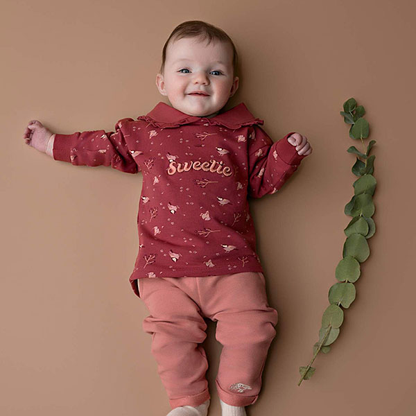 Dit leuke broekje is effen roze met 2 steekzakjes. De steekzakjes zijn afgezet met een lichtroze bies. Onder op het pijpje zit het logo van Little Robin (roodborstje) geborduurd. De pijpjes hebben een omslagrand. De tailleband is elastisch en enigszins gerimpeld.