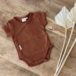 Dit mooie romper korte mouw Amber Brown komt uit de collectie van Little Indians. Het rompertje heeft een overslag en drukkertjes tussen de beentjes. Sfeerfoto