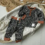 Een leuk broekje met zwarte ondergrond en witte dino print uit de Dino Park collectie van Frogs and Dogs. Het broekje heeft aan de zijkant 2 zakjes en een elastische broeksband. Broeksband en boorden pijpjes zijn in het bruin.