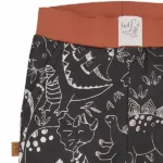 Een leuk broekje met zwarte ondergrond en witte dino print uit de Dino Park collectie van Frogs and Dogs. Het broekje heeft aan de zijkant 2 zakjes en een elastische broeksband. Broeksband en boorden pijpjes zijn in het bruin.