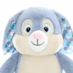 Clovis Brampton Blue Bunny Polka Dot is een heel lief en zacht knuffelkonijn. Hij heeft een blauw lichaam met een pluizige blauwe staart. Zijn vacht is lekker zacht en hij heeft grote slappen oren met aan de binnenkant gekleurde stippen. Zijn wangen zijn schattig mollig en hij heeft grote blauwe ogen.