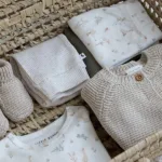 Een schattig gebroken wit shirt van zacht katoen met lange mouw van Little Goose. Het shirtje heeft een over-all print van ganzen en vijverplanten.