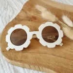 Een leuke zonnebril in de kleur beige van het merk Rammelaartje voor de kleintjes. Het montuur is glad en en heeft een gebloemde rand.