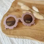 Een leuke zonnebril in de kleur oudroze van het merk Rammelaartje voor de kleintjes. Het montuur is glad en en heeft een gebloemde rand.