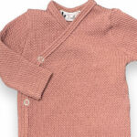 Dit lieve overslagshirt Cable Clay Pink met lange mouw in de kleur oudroze komt uit de collectie Feathers. Dit mooie overslagshirtje is gemaakt van organisch katoen en heeft een fijne kabelmotief. Het overslagshirtje sluit met 2 drukkertjes.