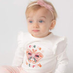 Wit shirtje met lange mouwen, geborduurde vlinder en tekst “Free as a Butterfly”. Met rucherand en drukknoopsluiting achteraan.