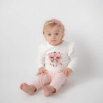 Wit shirtje met lange mouwen, geborduurde vlinder en tekst “Free as a Butterfly”. Met rucherand en drukknoopsluiting achteraan.