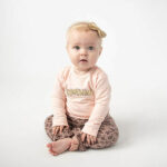 Deze schattige roze sweater Sunshine komt uit de  collectie Jungle van Frogs and Dogs. De sweater is effen van kleur met op de voorzijde in het 'goud' de tekst Sunshine. De hals en de boord aan de onderkant zijn afgewerkt met een gebroken witte kant randje.