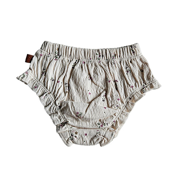 Deze mooie gebroken witte bloomer komt uit de Spring Lucky collectie van Frogs and Dogs. De bloomer is ook gemaakt van gekreukte stof en heeft op een overall print van bloemetjes. Aan de bovenkant zit een elastische rand met een sierstrikje. Onder de elastisch rand zit het logo van de lijn genaaid.
