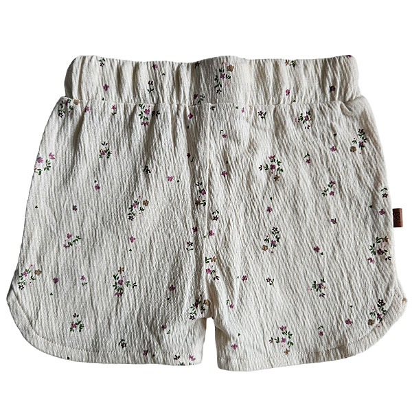 Hier vindt je het leuke korte broekje van gekreukte stof uit de collectie Spring Lucky van Frogs en Dogs. Deze korte broek in de kleur gebroken wit en een overall print van kleine bloemetjes. Aan de voorzijde zitten 2 nep steekzakjes. De pijpjes van het broekje lopen rond.