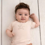 Dit leuke beige shirtje met korte mouw komt uit de Spring beach Clubh collectie van Frogs and Dogs. Op de voorkant van het shirtje staat een schattige print van een zeester. Het shirtje heeft aan de zijkant van de hals aan beide kant een drukkertje zitten.