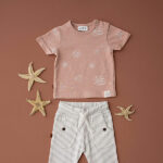 Dit leuke terracotta shirtje met korte mouw komt uit de Spring Beach Club collectie van Frogs and Dogs. Het shirtje heeft overall print van schelpen, zeesterren en slakken in een lichtere kleur. Op de linkerschouder zitten 2 drukkertjes.