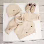 Beige teddy babyjasje met twee voorzakjes, gestikt Amour-logo en beige bies uit de Amour-collectie van Frogs and Dogs
