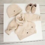 Dit zachte teddy sjaal in de kleur Beige komt uit de Amour van Frogs and Dogs. De sjaal heeft een 'gleuf' waarmee je hem vast kan maken. 