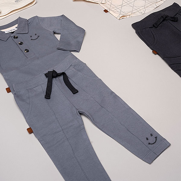 Dit leuke broekje in de kleur grijs komt uit de Smile Club collectie van Frogs and Dogs. Het broekje is effen van kleur en heeft aan de voorzijde 2 steekzakjes. Op de achterkant zitten 2 kontzakjes. De tailleband is elastisch met een koord. De pijpjes zijn gezoomd. Op het linker pijpje is aan de onderzijde een smiley geborduurd.