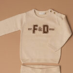 Deze mooie fijn gebreide sweater in de kleur beige komt uit de Smart Club collectie van Frogs and Dogs. De sweater is gemaakt van zacht katoen. Op de voorzijde zijn de letters F&D geborduurd met wollige bruine garen waardoor het er echt op ligt.