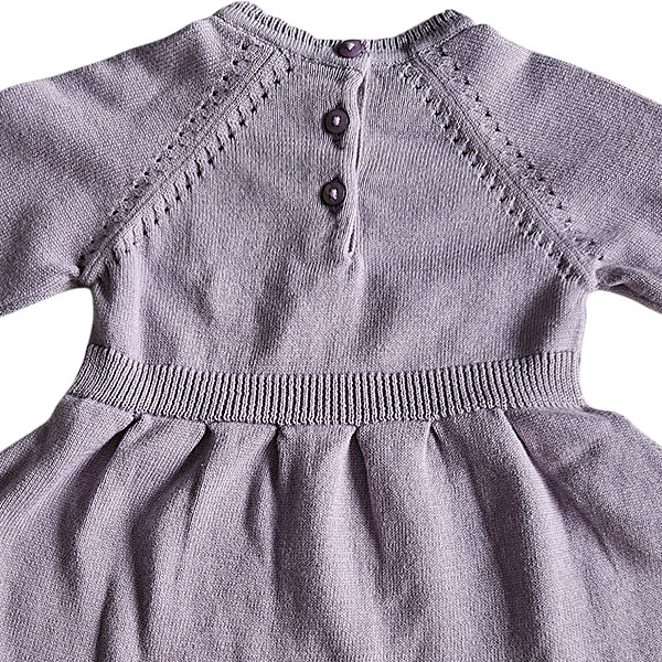 Deze mooie paarse jurkje komt uit de collectie Simply Nice Girl van Frogs and Dogs. Het jurkje heeft een wijd uitlopend rokje. Zowel de onderkant van het rokje als de onderkant van de mouwen hebben een gebreid rufflerandje met motief. Het jurkje heeft raglanmouwen met een gebreid motiefje op de naad. Op de achterzijde zit een sluiting met 3 knoopjes.