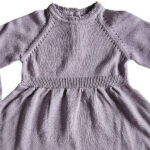 Deze mooie paarse jurkje komt uit de collectie Simply Nice Girl van Frogs and Dogs. Het jurkje heeft een wijd uitlopend rokje. Zowel de onderkant van het rokje als de onderkant van de mouwen hebben een gebreid rufflerandje met motief. Het jurkje heeft raglanmouwen met een gebreid motiefje op de naad. Op de achterzijde zit een sluiting met 3 knoopjes. 