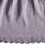 Deze mooie paarse jurkje komt uit de collectie Simply Nice Girl van Frogs and Dogs. Het jurkje heeft een wijd uitlopend rokje. Zowel de onderkant van het rokje als de onderkant van de mouwen hebben een gebreid rufflerandje met motief. Het jurkje heeft raglanmouwen met een gebreid motiefje op de naad. Op de achterzijde zit een sluiting met 3 knoopjes. 