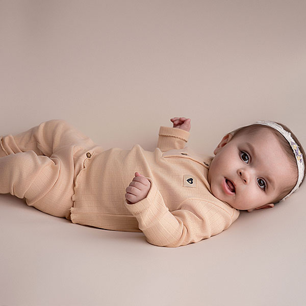 Zalmkleurig babyshirtje met ribstructuur, kanten afwerking en houten knoopjes uit de Amour wintercollectie van Frogs and Dogs