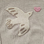 Deze schattige gebreide sweater komt uit de collectie Paloma van Frogs and Dogs. De sweater is effen beige met op de voorzijde een op geborduurd vogel met hartje, van wollige draad. Aan de binnenzijde is vlies gebruik waardoor de huid van je kleintje beschermd wordt. De boorden zijn gebreid en effen van kleur en op de schouder zitten 2 knoopjes.