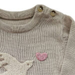 Deze schattige gebreide sweater komt uit de collectie Paloma van Frogs and Dogs. De sweater is effen beige met op de voorzijde een op geborduurd vogel met hartje, van wollige draad. Aan de binnenzijde is vlies gebruik waardoor de huid van je kleintje beschermd wordt. De boorden zijn gebreid en effen van kleur en op de schouder zitten 2 knoopjes.