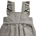 Deze leuke tuinbroek is gemaakt van geruite stof in de kleuren beige en gebroken wit. Deze tuinbroek komt uit de collectie Simply Nice Girl van Frogs and Dogs. Het tuinbroekje heeft aan de voorzijde 2 zakjes en aan de schouderbandjes zitten een ruffle rand. De pijpjes hebben een gezoomde rand met een elastiek. 