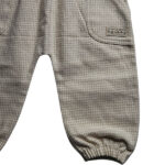 Deze leuke tuinbroek is gemaakt van geruite stof in de kleuren beige en gebroken wit. Deze tuinbroek komt uit de collectie Simply Nice Girl van Frogs and Dogs. Het tuinbroekje heeft aan de voorzijde 2 zakjes en aan de schouderbandjes zitten een ruffle rand. De pijpjes hebben een gezoomde rand met een elastiek. 