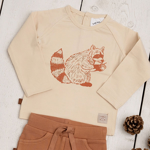 Dit leuke shirtje met lange mouw in de kleur cappuccino komt uit de Racoon Club collectie van Frogs and Dogs. Het shirtje is gemaakt van fijne ribstof. Op de voorzijde staat in de kleur bruin een print van een wasbeer met een eikeltje tussen zijn voorpoten. Het shirtje heeft een drukker sluiting op de rug.