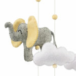 Kijk eens naar de prachtige houten mobiel van Ulysse! Met zijn betoverende  grijze olifanten en witte wolken geeft deze mobiel elke kinderkamer een dromerige uitstraling. Gemaakt van hoogwaardig vilt, zorgt deze mobiel niet alleen voor visuele prikkels, maar ook voor tastbare sensaties. De wolken zorgen voor een vrolijke en dromerige sfeer in de babykamer en helpen bij het kalmeren van jouw baby.