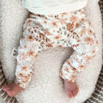 Dit mooie broekje Bloemen Perzik van Little Adventure heeft een elastische broeksband. Het broekje Bloemen Perzik heeft een off white ondergrond met daarop een leuke bedrukking van perzikkleurige bloemen en takjes met bladeren. De broeksband en boordjes van het broekje zijn gemaakt van dezelfde stof.Â