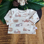 Deze leuke crèmekleurige shirt met lange mouwen komt uit de collectie van ByTasha Exclusive. Het shirtje heeft een een crèmekleurige ondergrond met daarop in zachte tinten grijs en bruin prints van tractoren, vrachtwagens en andere voertuigen. Het shirtje heeft een elastische hals en gezoomde boordjes.