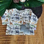 Deze leuke crèmekleurige shirt met lange mouwen komt uit de collectie van ByTasha Exclusive. Het shirtje heeft een een crèmekleurige ondergrond met daarop een bonte print van diverse jungle dieren zoals buffel, giraffe, luipaard, nijlpaard & olifant. De print is een digitale print. Het shirtje heeft een elastische hals en gezoomde boordjes.