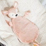 Dit leuke knuffeldoekje Deer Pale Pink komt uit de collectie van Jollein en kan de hele dag met jouw baby knuffelen. Het doekje is roze gebreid aan de voorzijde en heeft een zachte achterkant van fleece materiaal in de kleur crème.  Het doekje heeft het hoofdje van een hertje en een lusje waarmee je hem ook aan de speen kan bevestigen. Zo raak de speen minder snel kwijt.